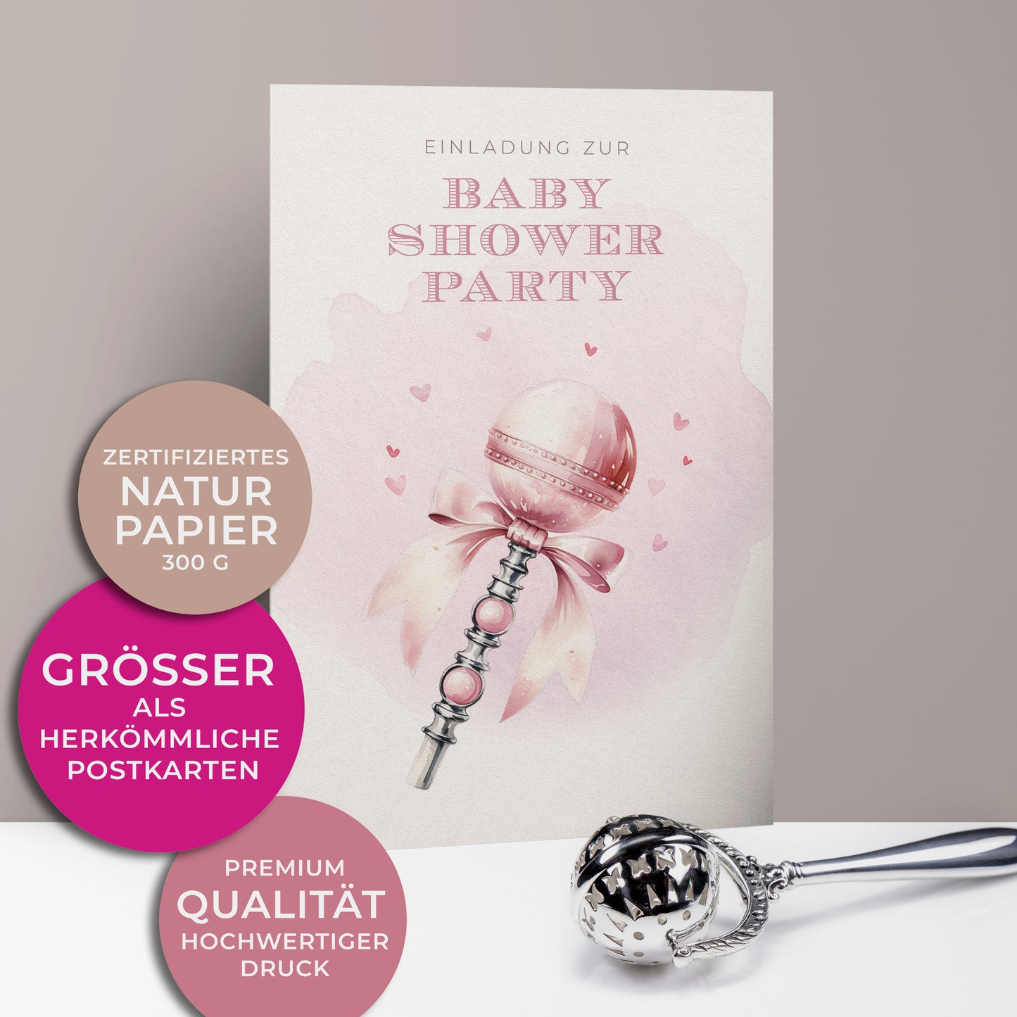 Einladungskarten zur Baby Shower Party für Mädchen, Kleine silber und rosafarbene Babyrassel mit Schleife und Herzchen im Hintergrund