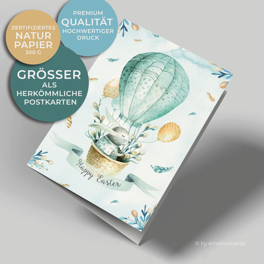 Osterkarte Hochformat, Osterhase im Heißluftballon sitzend mit Palmkätzchen und gelben Luftballons.